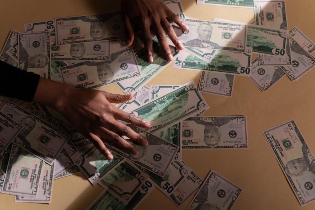 Hands on Table with Dollar Bills